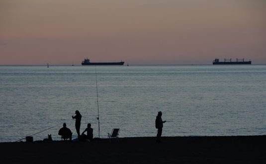 Gente pescando en la playa de Ereaga